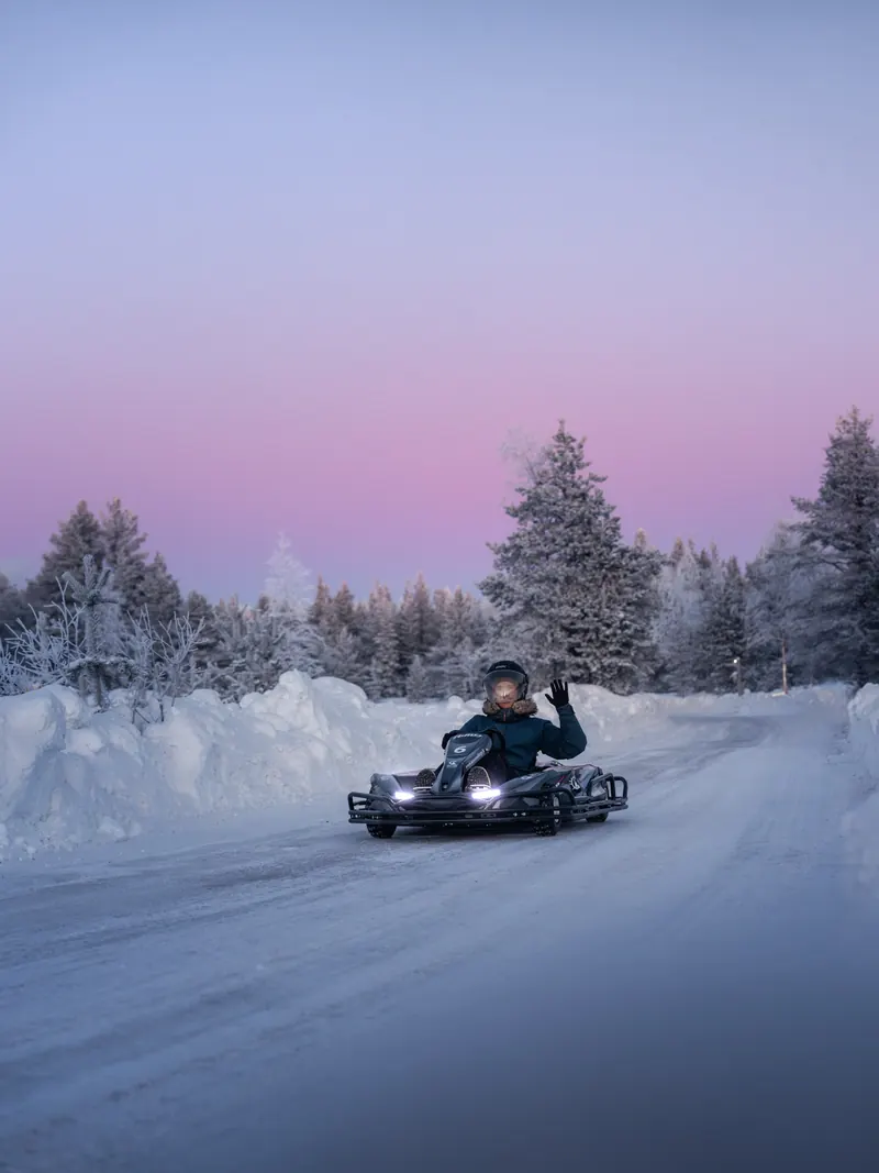 Ice karting on a snowy track under a pink winter sky